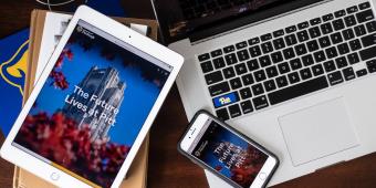 an ipad, an iphone, and a laptop scattered on a desk