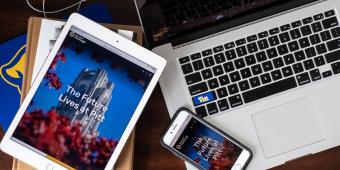 a laptop, an ipad, and an iphone scattered on a table