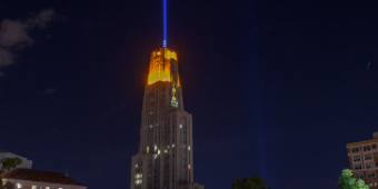 Gold and Blue victory lights on top of the Cathedral of Learning at night